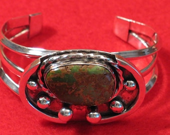 Silver cuff style bracelet with green turquoise cabochon