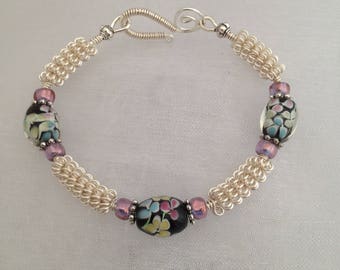 Silver wirework bracelet, with black floral lampwork beads.