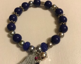 Purple beaded bracelet with tassel charm