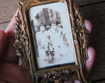An antique small metal photo frame, simple frame to show eight plate size photos