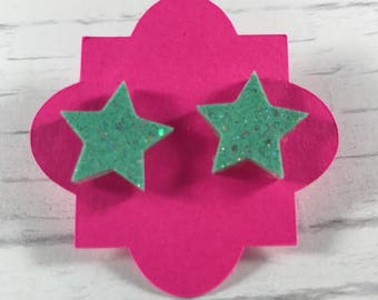 Star shaped resin earrings with embedded glitter, pierced.