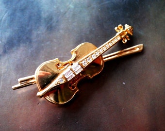 Callsy vintage 80s,bold, gold tone metal ,figural,violin brooch with clear crystals. Made by Swarovsky.