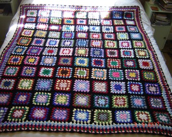 Multi-coloured crocheted wool blanket.