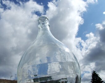 Italian demijohn. Old 5 liter wine bottle demijohn, country rustic decor. Transparent glass carboy