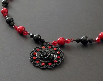 Red and black beaded necklace with rosette pendant and red glass pearl earrings