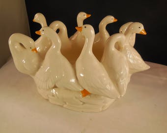 Vintage ceramic geese in a circle around a bowl.