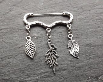 Silver coloured brooch with tree branch design pin and leaf dangles.