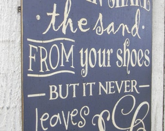 You can shake the sand from your shoes but it never leaves your soul - typography word art beach wood sign