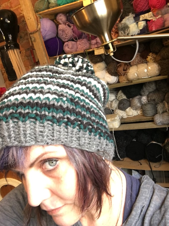 Slouchy handknit striped hat in our favorite teams colors . Warm and soft with a pompom to boot!