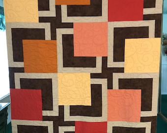Modern quilt with rich earth tones --- browns, peach, orange, yellow fabric.