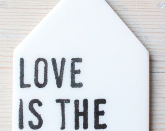 porcelain wall tag screenprinted text love is the answer.