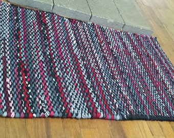 Black and red twined rag rug,