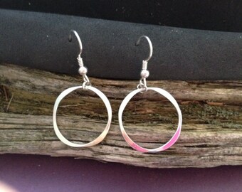 Round forged dangle silver earring.