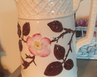 Antique pitcher with pink wild rose