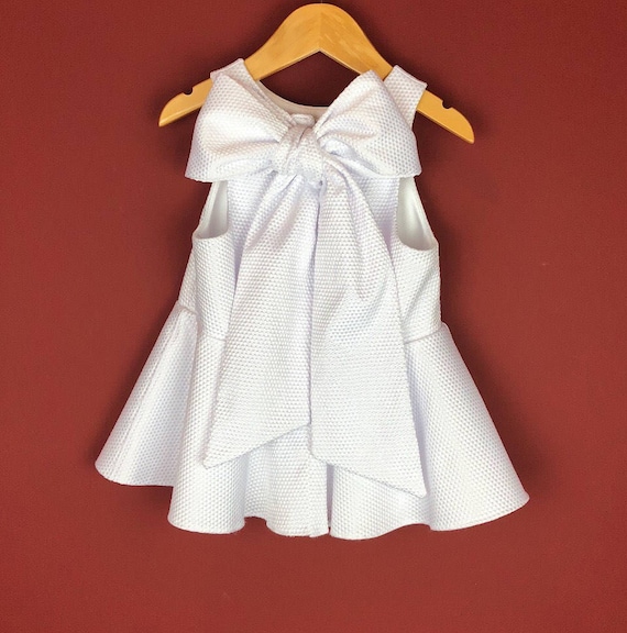 The "Bow-Backed Peplum" in White Pique.