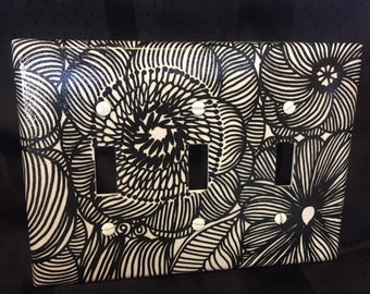 Black and white floral triple switch plate cover.