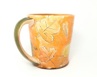 Orange fall leaf themed Earthenware mug. Wheel thrown, food safe leafy mug made by Kaitlyn Brennan