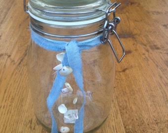 Glass vase with seashells and Blue Ribbon