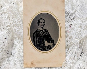 Tintype photograph of a beautiful fashionably dressed woman in a paper frame wearing plaid