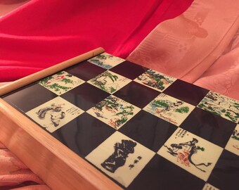 Vintage Folding Chess board adorned with Japanese artwork and figures Natural color wood with plastic overlay surface