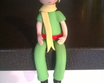 Decorative figurine: boy sitting in cold porcelain.