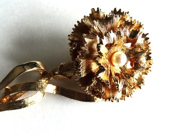 Gold tone carnation brooch. Pearl in center.Unsigned beauty but might be missing a part.