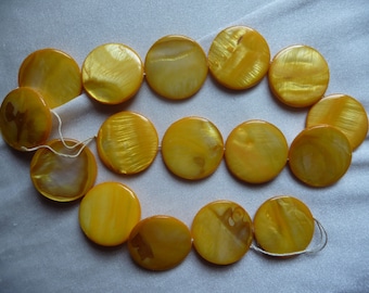 Mother of Pearl, 25mm Flat Round Coin, Shades of Yellow. Sold per 15 inch strand. There are 16 beads on the strand.