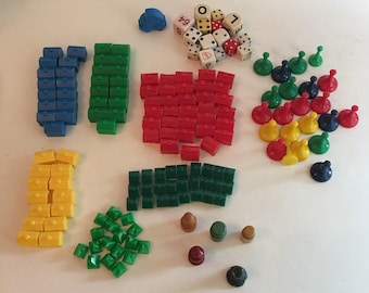 Vintage 70's lot of 143 game pieces. Monopoly houses, hotels, dice, plastic spacers, and wooden spacers.