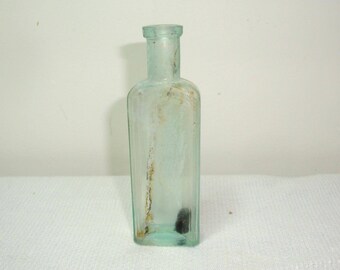 Old corked bottle. 4" tall, 1.25" wide, 5/8" thick. Dug bottle was washed in mild soapy water. Some residue and cork remain. Diamond mark