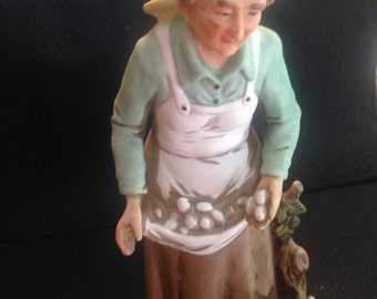 Old women with egg basket and rooster