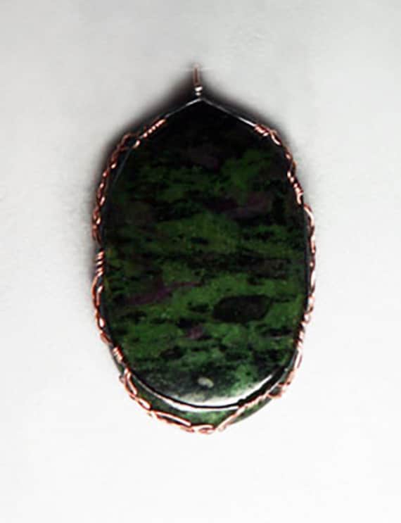 Ruby zoisite cabochon wrapped Celtic style in silver and gold
