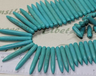 A strand of Graduated 45x5mm to 12x5mm Point Round Spike Turquoise Dyed Magnesite.