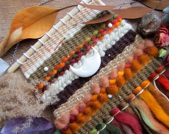 Bohemian woven tapestry wall hanging in earthy / Autumn colors with carved crescent, white howlite, and silver beads. Size 7" x 15"