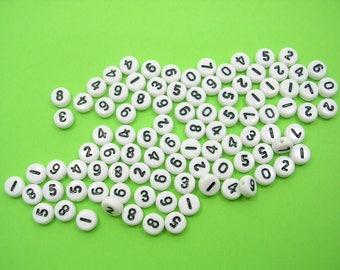 100 white round beads with 7mm black figure