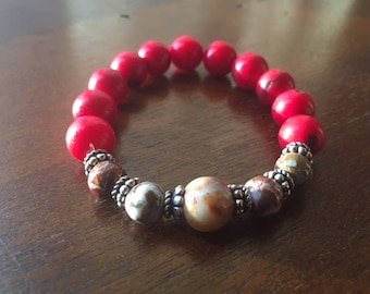 Sophisticated, red coral gemstone bead bracelet with natural tourmaline accent beads surrounded by sterling silver spacer beads.