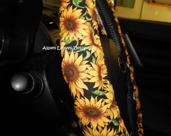 Sunflower Steering wheel cover. Yellow and gold sunflowers with green leaves on black. Seat belt covers and key fob options.