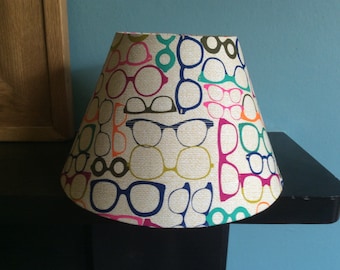 30cm coolio/square/drum/round table/ceiling lampshade. Beige background with multicoloured glasses.