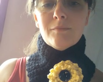 Black neckwarmer with yellow flower and black button