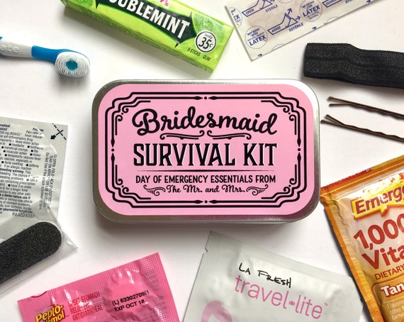[Image description: A tin saying "Bridesmaid Survival Kit, Day of emergency essentials from The Mr. and Mrs" lies in the middle of the frame. Surrounding it are different items like a plaster, hairpins, chewing gum, and a toothbrush.]