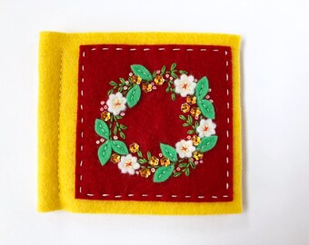 bright yellow and red felt needle book with hand embroidery and sparkly sequins