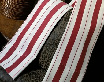 An adorable 3 pc bed sheet a lively bergundy and off white strip, vintage set. one full size flat sheet, with two matching pillow cases.