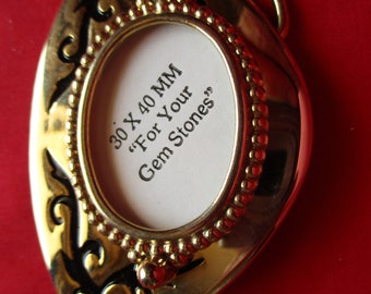 Gold Tone with black accents belt buckle. Holds a 30 x 40 mm cabachon.