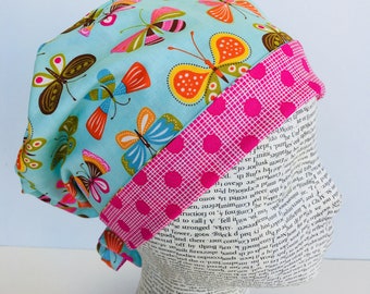 Tie Back Scrub Cap scrub hat featuring a blue material with butterflies in pink blue yellow green and orange with a coordinating band 2t