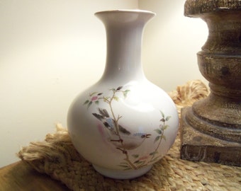 Vase with bird on cherry blossom branch