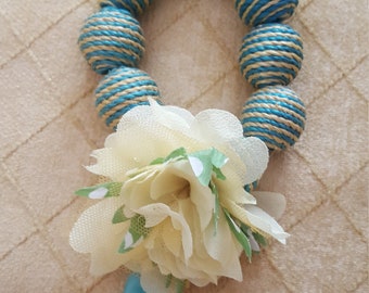 Floral handmade bracelet with green wicker balls.