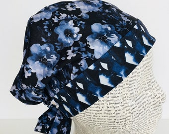 Tie Back Scrub Cap scrub hat featuring a dark blue material with flowers in a gray blue color with a coordinating band 2t