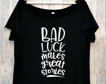 BAD LUCK. Slogan t-shirt. Raw edge neckline and sleeves. Loose fit. Wide, off the shoulder neckline.