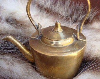 Brass teapot. A brass antique kitchenware. Ancient forged utensils.