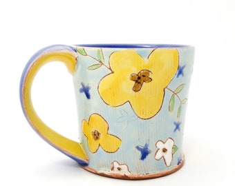 Floral yellow and blue mug. Wheel thrown earthenware mug. Handmade by Kaitlyn Brennan/Brennan pottery in Ottawa Ontario