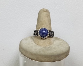 The ring has 10 mm Blue Sodalite in it. It is made of sterling silver size 9 1/2. this is the first ring with my new band.